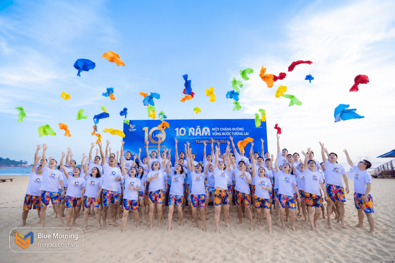 Áo team building công ty - tập thể nhân viên mặc áo thun team building trên bãi biển